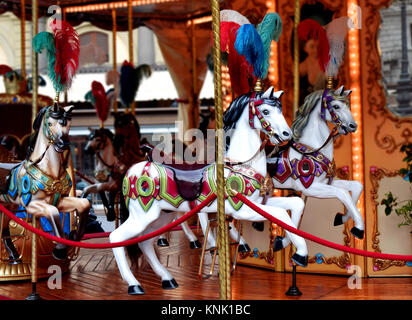 Fliegende weisse Pferde auf einem Karussell, einem Merry go round irgendwo in Florenz, Italien. Stockfoto