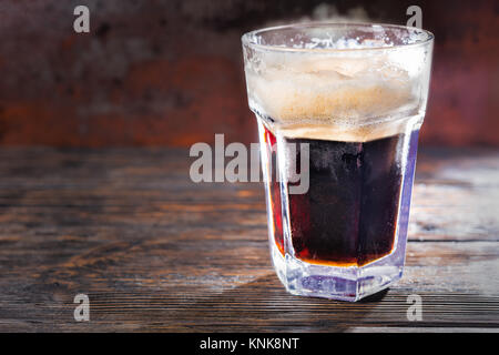 Grosse frozen Glas mit frisch gezapften Bier und Leiter der Schaum auf Holzschreibtisch. Nahrungsmittel und Getränke Konzept Stockfoto