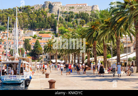 Touristen schlendern in der Riva Hafen unter der alten spanischen Festung - Hvar, Kroatien Stockfoto