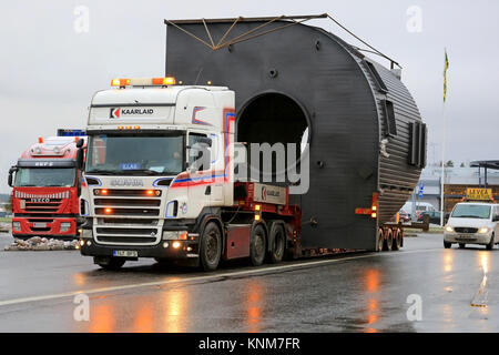 Mariehamn, Finnland - 30. NOVEMBER 2014: Scania Lkw schleppt eine große Last von Escort Autos begleitet. Auf finnische Straßen mindestens ein Begleitfahrzeug ist Abreissen Stockfoto