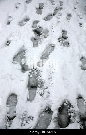 Fußabdrücke auf einem verschneiten Pflaster, Alverstoke, Gosport, Hampshire, England, UK: plötzliche Schnee Sturm im Dezember 2017 Stockfoto