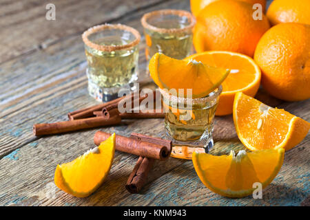 Gläser gold Tequila mit Orange und Zimt. Stockfoto