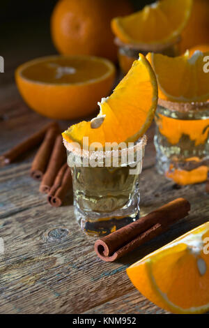 Gläser gold Tequila mit Orange und Zimt. Stockfoto