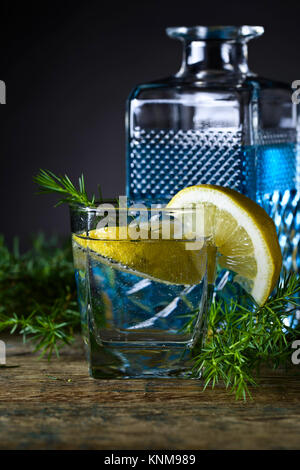 Gin mit Tonic, Zitronenscheiben und Wacholder. Stockfoto