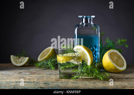 Gin mit Tonic, Zitronenscheiben und Wacholder. Stockfoto