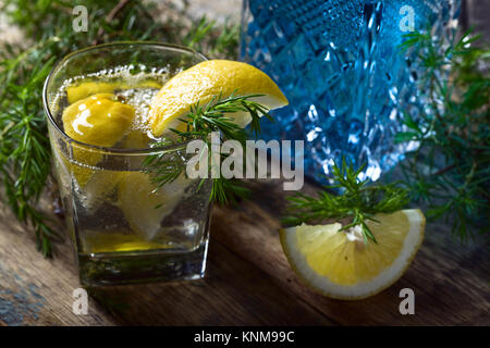 Gin mit Tonic, Zitronenscheiben und Wacholder. Stockfoto