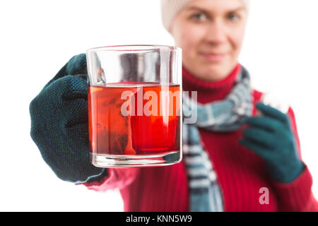 Kranke junge Frau mit einer Tasse heißen Tee tragen warme Kleidung mit Hut Schal und Handschuhe, wie die saisonale winter Krankheit Konzept Stockfoto