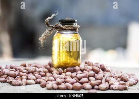 [Arachis hypogaea] Rohe Erdnuss in ein irdenes Gefäß mit Erdnussöl auf einem gunny Hintergrund.; Stockfoto