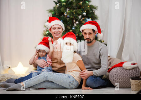 Bild der glücklichen Familie in Santa Stopfen am Weihnachtsbaum Stockfoto