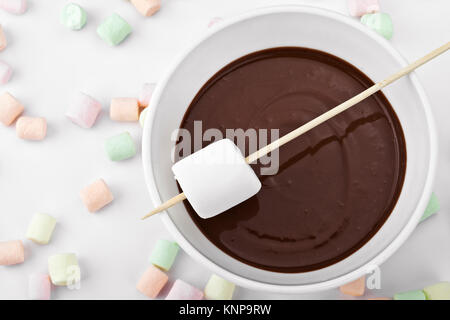 Bis geschlossen Marshmallow in einem Stick und geschmolzene Schokolade Stockfoto