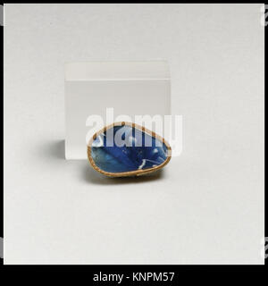 Dieses gerippte Schälfragment aus römischem Glasmosaik aus dem späten 1. Jahrhundert v. Chr. bis zum frühen 1. Jahrhundert n. Chr. zeigt ein durchscheinendes Kobaltblau und ein opakes weißes Band-Mosaikmuster. Die leicht konvex gewölbte Seite verjüngt sich nach unten, und das Äußere zeigt einen Teil von vier vertikalen Rippen mit abgerundeten Außenseiten, die sich nach unten verjüngen. Stockfoto