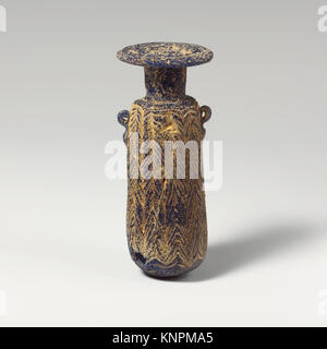Diese griechische Alabastron-Glasflasche aus dem späten 6. Bis 5. Jahrhundert v. Chr. ist kerngeformt und hat einen durchscheinenden blauen Körper mit rötlich-violetten Streifen, gelben und türkisfarbenen Pfaden und zwei vertikale Ringgriffe. Er ist 6,4 cm (1/2 Zoll) hoch. Stockfoto