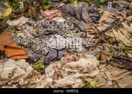 Ein Haufen alte und verschlissene Kleidung häuften sich in der Nähe des Flusses Aljucén in Mérida, Badajoz, Extremadura, Spanien. Stockfoto