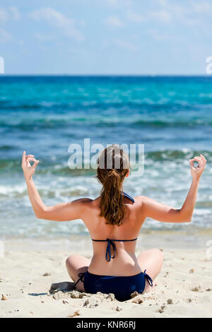 Frau Im Bikini Macht Joga bin Strand, Spanien, Ibiza - Frau tut Yoga am Strand, Ibiza, Spanien Stockfoto