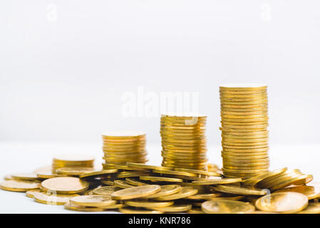 Einsparungen, Erhöhung der Spalten von Goldmünzen, Stapel von Goldmünzen als Grafik auf weißem Hintergrund, Business Banking Idee, flacher konzentrieren. Stockfoto