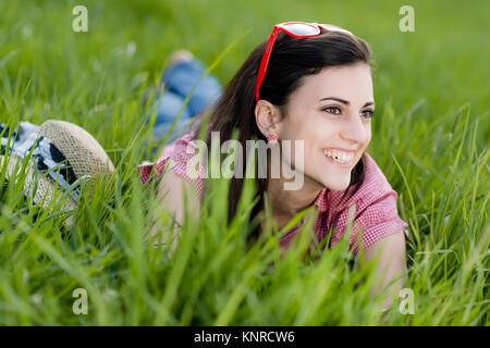 Junge Frau Liegt in der Fruehlingswiese - junge Frau auf der Frühlingswiese Stockfoto