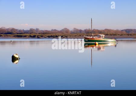 Hölzerne Segelboot "Jesus" auf eine ruhige und friedliche Winter am Nachmittag auf dem Fluß Deben an Waldringfield, Suffolk, Großbritannien. Stockfoto