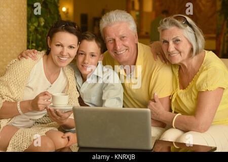 Familie in der Nähe von Tabelle mit Laptop Stockfoto