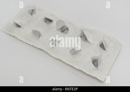 Pillen Platte von Remedy für Lebensmittelvergiftungen. alle Tabletten eingenommen, Papier zerrissen und schwarz links Trace Stockfoto