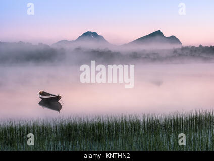 Sehr friedliche Sommernacht mit hölzernen Boot und Nebel auf den Lofoten, Norwegen Stockfoto