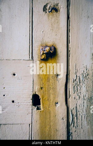 Detail einer alten hölzernen Tür von einem alten Gebäude in einem Zustand des Verfalls. Stockfoto