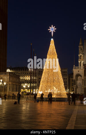 Die Leute bewundern die beleuchtete Weihnachtsbaum an der Piazza San Marco, San Marco, Venedig, Venetien, Italien. Leichte Bewegungsunschärfe auf die Menschen. Stockfoto