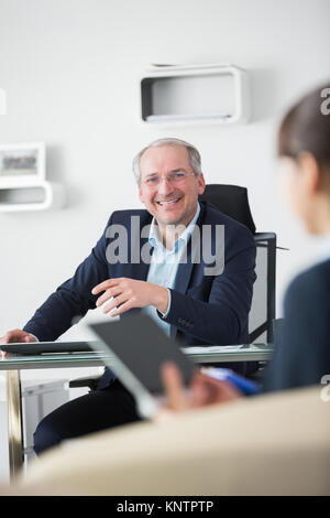 Portrait von lächelnden älteren Geschäftsmann im Tagungsraum im Büro sitzen Stockfoto