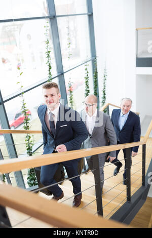 Hohen winkel Portrait von junge Unternehmer bewegen im Obergeschoss mit Kollegen im Büro Stockfoto