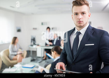 Portrait von ernsthaften Geschäftsmann Holding digital Tablet im Tagungsraum im Büro Stockfoto