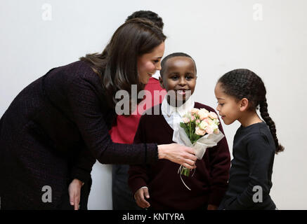 Die Herzogin von Cambridge spricht zu Yahya Hussein Ali 7 und Dawud Wahabi 10, Kinder, die durch die Grenfell Turm Brand betroffen sind, und Ailise Taylor 7, bei ihrem Besuch in der Rugby Portobello Vertrauen Community Center in North Kensington, London, wo sie Kinder und Familien in die Arbeit des Vertrauens zu feiern. Stockfoto