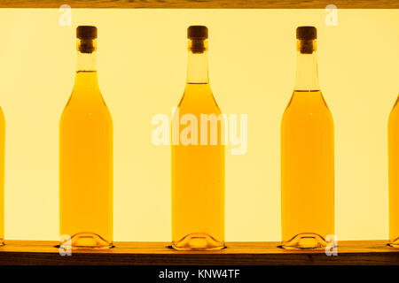 Abstrakte Gelb Klar Glas Flaschen Regal mit Hintergrundbeleuchtung Stockfoto