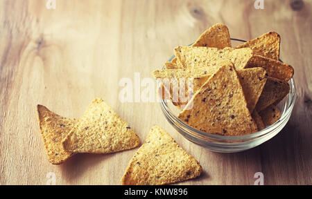 Mais Chips in der jar. Traditionelle Snack für Bier mexikanische Nachos. Nachos mit Gewürzen und Pfeffer auf Holztisch. Stockfoto