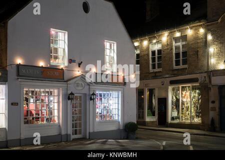 Geschäfte auf dem Marktplatz mit Weihnachtsschmuck in der Nacht. Verstauen auf der Wold, Cotswolds, Gloucestershire, England Stockfoto