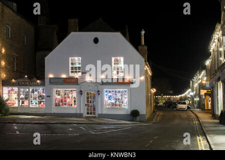 Geschäfte auf dem Marktplatz mit Weihnachtsschmuck in der Nacht. Verstauen auf der Wold, Cotswolds, Gloucestershire, England Stockfoto