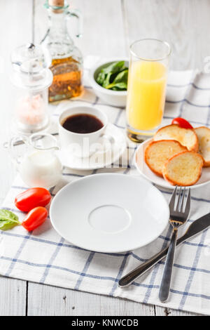 Weiße Platte, Kaffee und Orangensaft auf einem weißen Holztisch. Serviert zum Frühstück Stockfoto