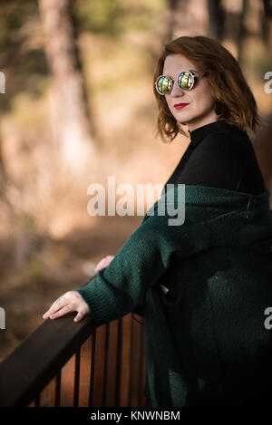 Frau mit Sonnenbrille Possing im Park Stockfoto