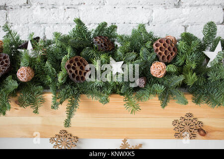 Nahaufnahme von Details der Grüne Weihnachten Girlande mit Ratten Kugeln dekoriert, getrocknete Blumen von Lotus und Holz- Sterne. Horizontale Farbbild. Stockfoto