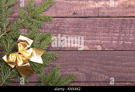 Weihnachtsbaum dekoriert roten Bogen, Zweige und Zapfen auf hölzernen Hintergrund Stockfoto