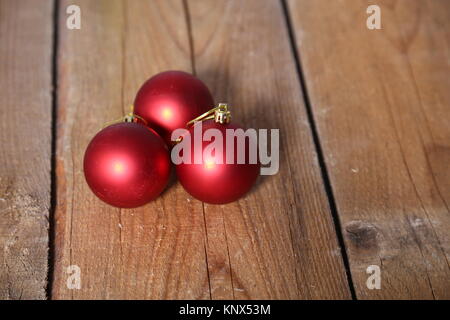 Drei rote Weihnachtskugeln über Holz- Hintergrund Stockfoto