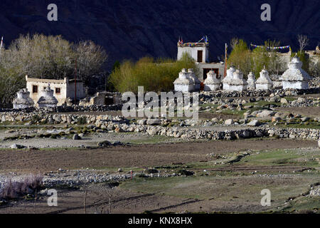 Weißer Stein buddhistischen Stupas am Rande eines gepflügten Feldes des Frühlings, den Himalaya. Stockfoto