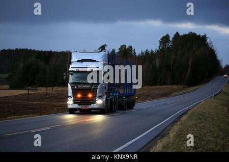 SALO, Finnland - 8. DEZEMBER 2017: Helle Zusatzleuchten und Scheinwerfer von Scania R620 Streamline logging Truck leuchten Landstraße auf frühen Winte Stockfoto