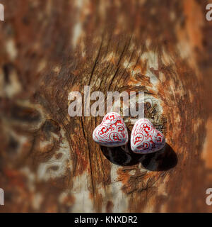 Zwei schöne rote und weiße Herzen nebeneinander liegend auf einer hölzernen, alte stoleshnitse. Otkrytka zu syatogo Tag Valentinstag. Stockfoto