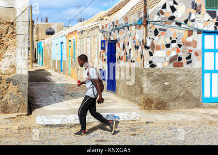 Lokale vorbei gehen traditionelle Gehäuse in einer Seitenstraße von Santa Maria, Sal, Salinas, Kap Verde, Afrika Stockfoto