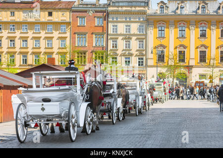 Pferdekutschen für Touren der Stadt Krakau online verfügbar im Marktplatz der Stadt, Polen. Stockfoto
