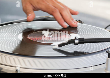 Der dj benutzt Vinyl-Schallplatten zu mischen Sie elektronische Musik und Rap-Sound zu schlagen. Stockfoto