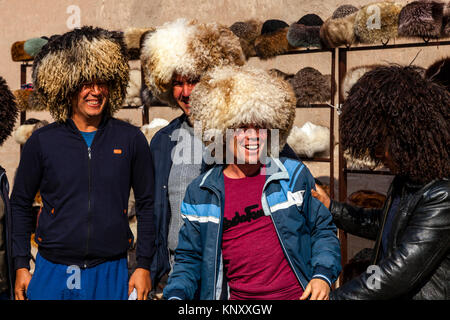 Eine Gruppe von usbekischen Touristen Lachen, als Sie versuchen auf traditionellen Kammgarn Hüte, Chiwa, Usbekistan Stockfoto