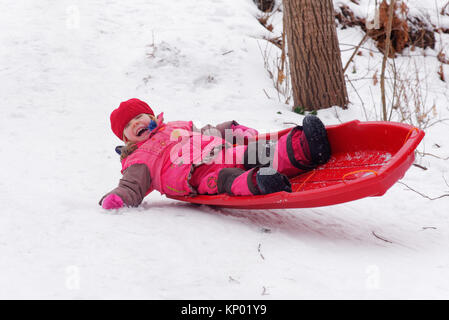 Ein kleines Mädchen (3 Jahre alt) Rodeln in Quebec Stockfoto
