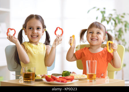 Lustige Kinder spielen und essen im Kindergarten Stockfoto