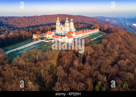 Kamaldulenserkloster und barocke Kirche in den Wald auf dem Hügel in Bielany, Krakau, Polen, Luftaufnahme im Abendlicht mit weitem Blick auf Krakau Stadt Stockfoto