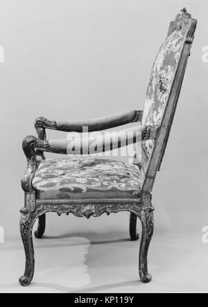 Ein französischer Sessel (Fauteuil) aus dem ersten Viertel des 18. Jahrhunderts, geschnitztes und vergoldetes Buchenholz, mit Wandteppichen aus Wolle Aubusson, 47 1/2 x 27 1/2 x 21 5/8 cm, Teil der MET-Kollektion, ein Beispiel für französisches Möbeldesign und Handwerk dieser Zeit. Stockfoto